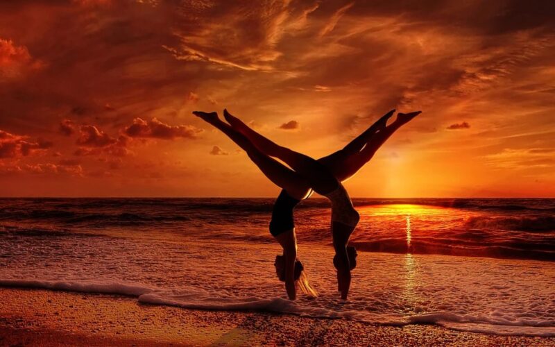 Couple Doing Yoga on Beach